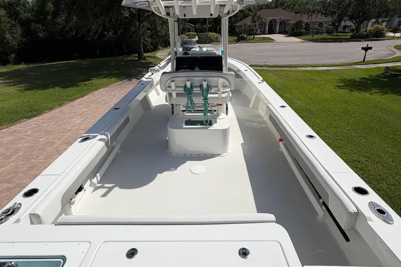 Slide: The Image of 2022 Parker 2801 Center Console boat with spacious deck and seating, parked on a driveway. - 13