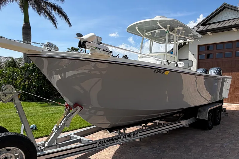 Slide: The Image of 2022 Parker 2801 Center Console boat on trailer, parked in driveway under clear sky. - 4