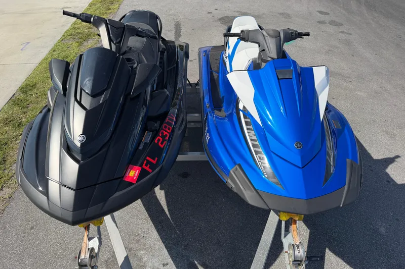 Slide: The Image of Two Yamaha WaveRunner VX Limited jet skis, black and blue, parked on trailers. - 2