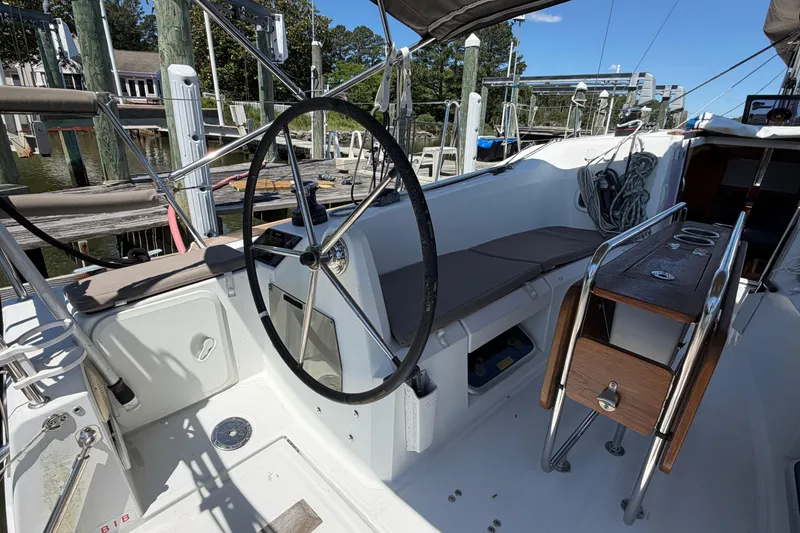Slide: The Image of 2015 Jeanneau Sun Odyssey 349 cockpit with steering wheel and seating at marina. - 19