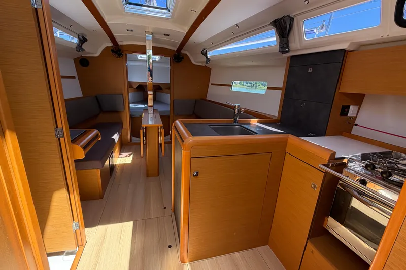 Slide: The Image of Interior of 2015 Jeanneau Sun Odyssey 349 sailboat, featuring modern kitchen and seating area. - 22