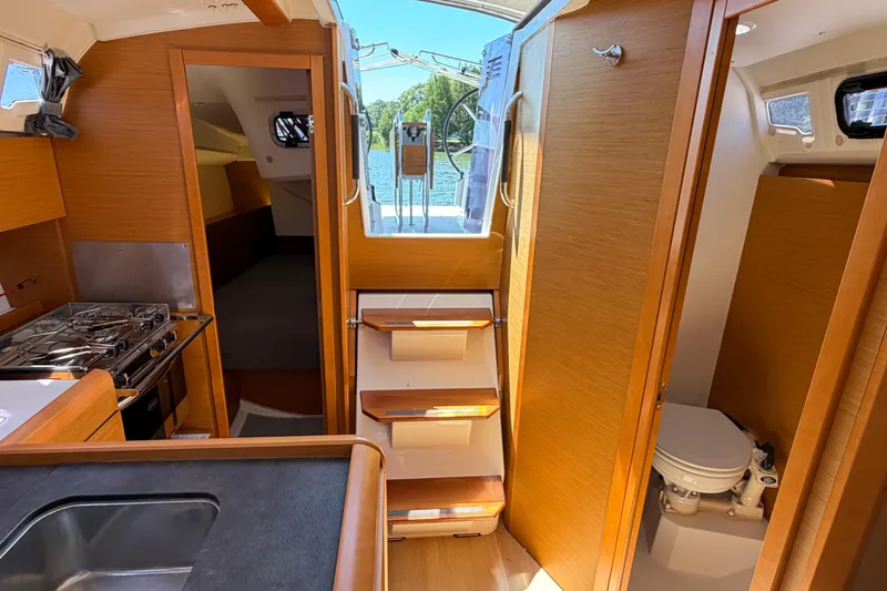 Slide: The Image of Interior of 2015 Jeanneau Sun Odyssey 349 sailboat, featuring kitchen, cabin, and bathroom. - 24
