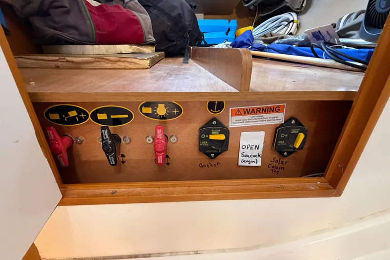 Slide: The Image of Electrical panel on a 2015 Jeanneau Sun Odyssey 349 sailboat with warning labels. - 33