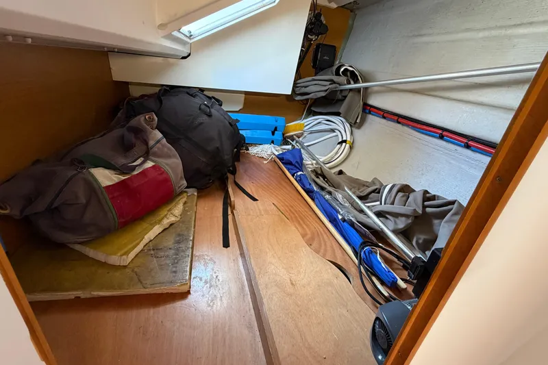 Slide: The Image of Storage area inside a 2015 Jeanneau Sun Odyssey 349 sailboat, featuring bags and sailing equipment. - 34