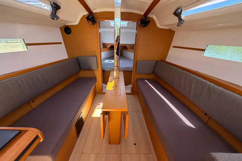 Slide: The Image of Interior of 2015 Jeanneau Sun Odyssey 349 sailboat, featuring cozy seating and wooden finishes. - 39