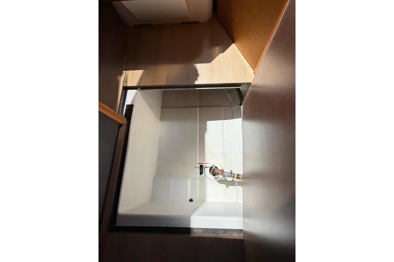 Slide: The Image of Storage compartment inside 2015 Jeanneau Sun Odyssey 349 sailboat, featuring a clean, white interior. - 46
