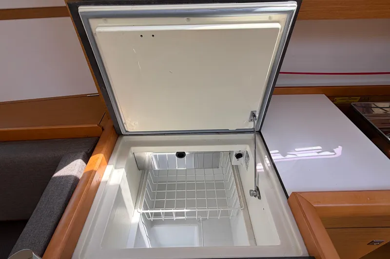 Slide: The Image of Open refrigerator in 2015 Jeanneau Sun Odyssey 349 yacht interior, showcasing storage space. - 48