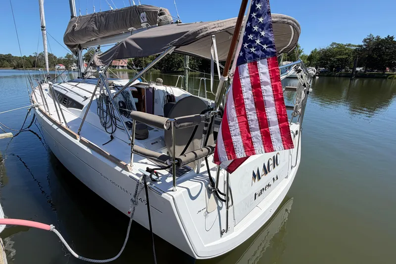 Slide: The Image of 2015 Jeanneau Sun Odyssey 349 sailboat docked with American flag displayed. - 5