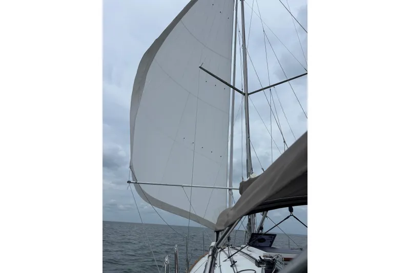 Slide: The Image of Sailing on a 2015 Jeanneau Sun Odyssey 349 with full sails against a cloudy sky. - 53