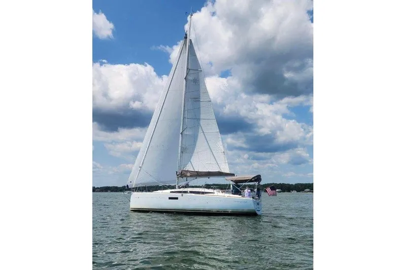Slide: The Image of 2015 Jeanneau Sun Odyssey 349 sailing on a lake under a partly cloudy sky. - 54