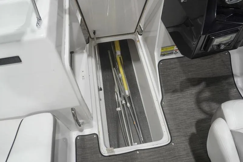 Slide: The Image of 2022 Glastron GTD 220 boat storage compartment with metal rods, open hatch view. - 10