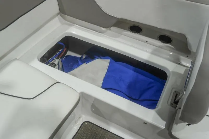 Slide: The Image of 2022 Glastron GTD 220 boat storage compartment with blue cover inside. - 14