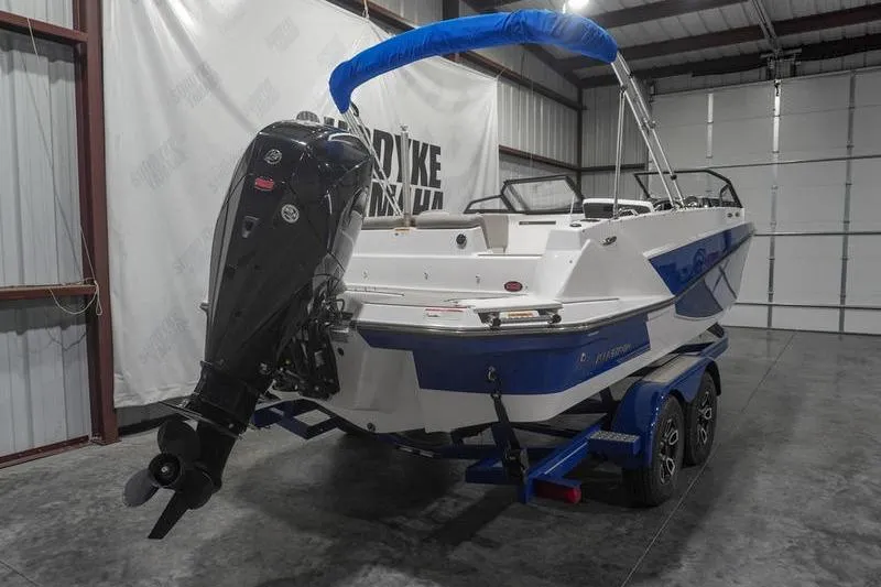 Slide: The Image of 2022 Glastron GTD 220 boat with blue accents and outboard motor in a garage. - 3
