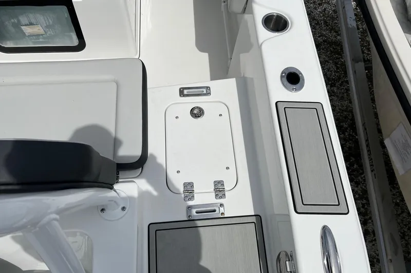 Slide: The Image of Interior view of 2026 Sea Pro 245FLX Sandbar boat, featuring seating and storage compartments. - 16