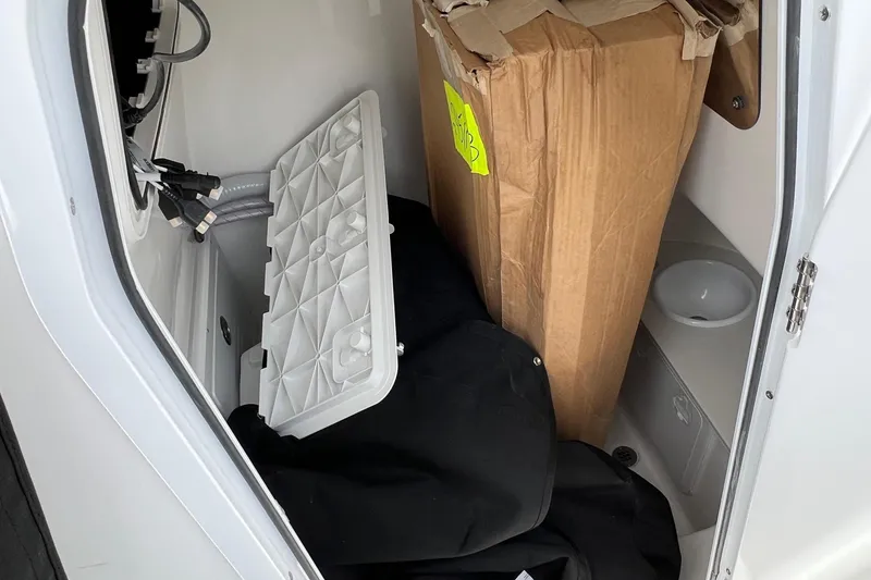Slide: The Image of Storage compartment of 2026 Sea Pro 245FLX Sandbar boat with various items inside. - 24