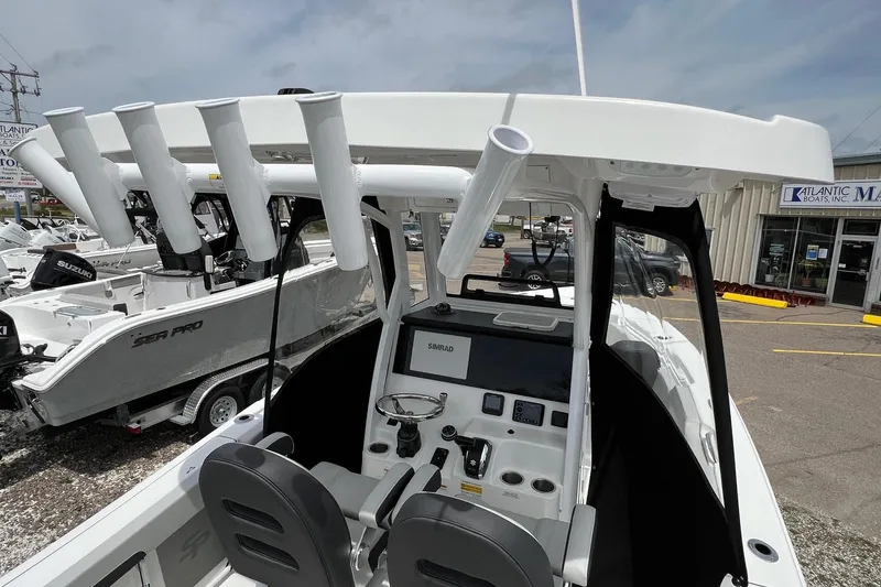 Slide: The Image of 2026 Sea Pro 245FLX Sandbar boat interior with rod holders and control panel. - 9