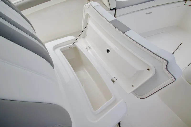 Slide: The Image of 2027 Regulator 25 boat interior storage compartment with open lid, showcasing sleek design. - 19