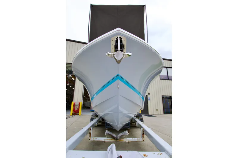 Slide: The Image of 2027 Regulator 25 boat on trailer, front view at a marina. - 2