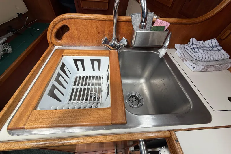 Slide: The Image of 1982 Sabre 34 yacht kitchen sink with wooden trim and dish rack. - 10