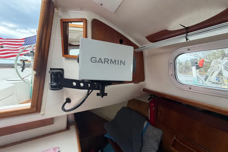 Slide: The Image of Garmin navigation system inside a 1982 Sabre 34 sailboat cabin with American flag visible. - 14