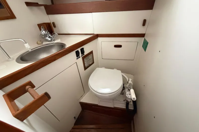 Slide: The Image of Compact bathroom in a 1982 Sabre 34 sailboat with sink and marine toilet. - 23