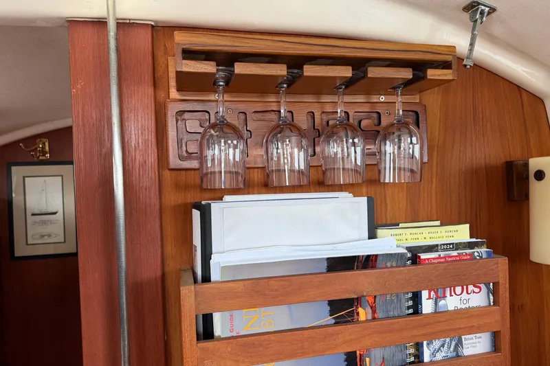 Slide: The Image of Interior of 1982 Sabre 34 yacht with wine glasses and books on wooden shelves. - 24