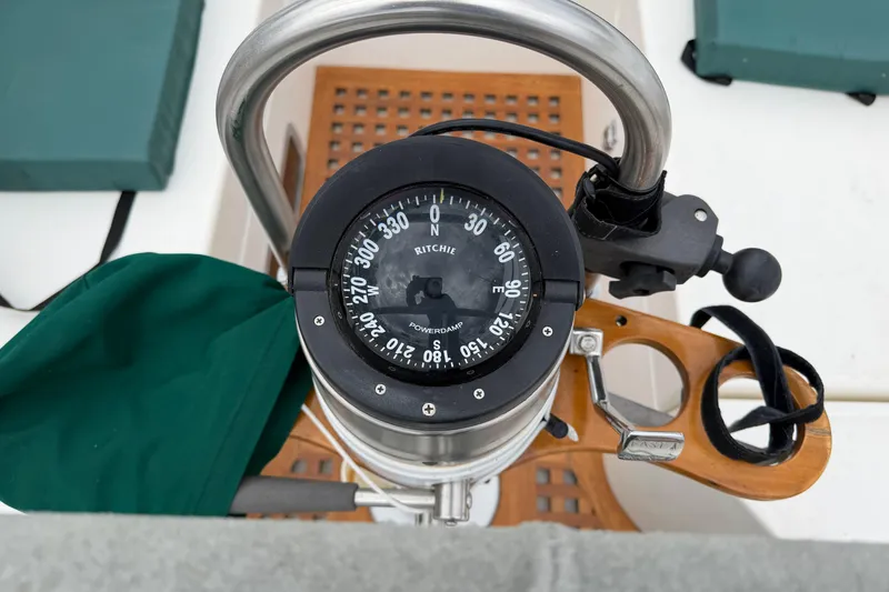 Slide: The Image of Compass on 1982 Sabre 34 sailboat helm, featuring wooden and metal elements. - 35
