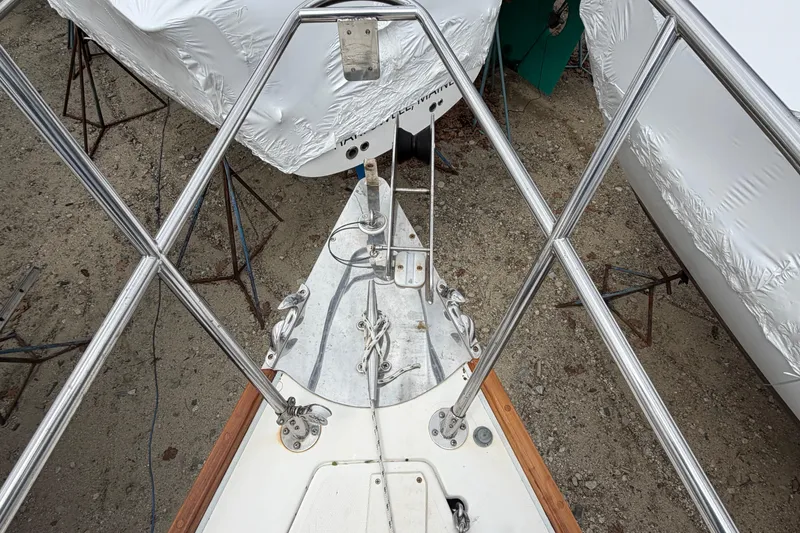 Slide: The Image of Bow view of a 1982 Sabre 34 sailboat, featuring stainless steel railings and anchor setup. - 37