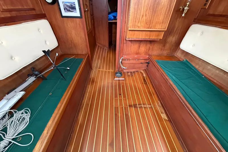 Slide: The Image of Interior of 1982 Sabre 34 sailboat with wooden flooring and green cushioned seating. - 4