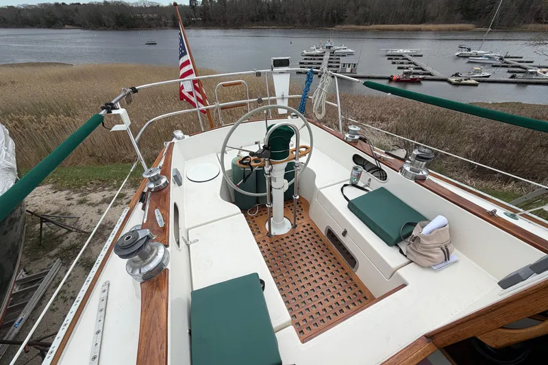 Slide: The Image of Cockpit of 1982 Sabre 34 sailboat with American flag, docked near a serene lake. - 40