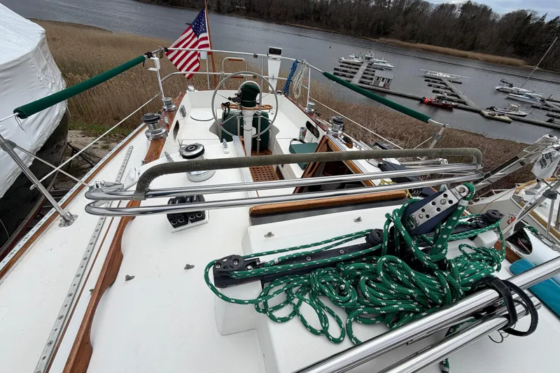 Slide: The Image of 1982 Sabre 34 sailboat deck with ropes, docked near a serene waterfront. - 45