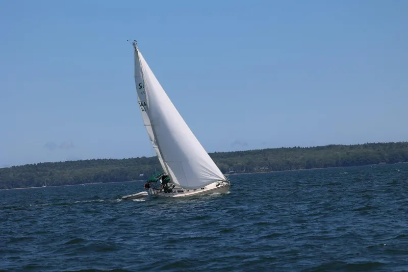 Slide: The Image of 1982 Sabre 34 sailboat navigating open waters under clear blue skies. - 49