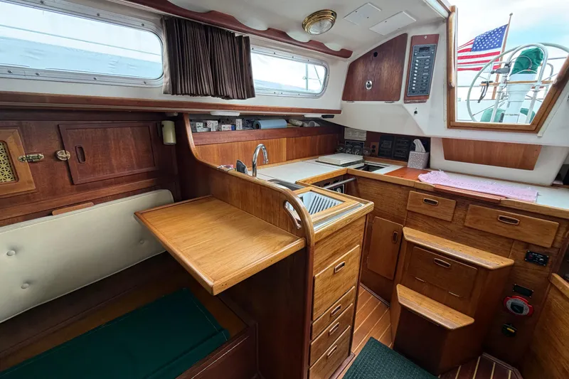Slide: The Image of Interior of a 1982 Sabre 34 sailboat featuring a wooden galley and seating area. - 5