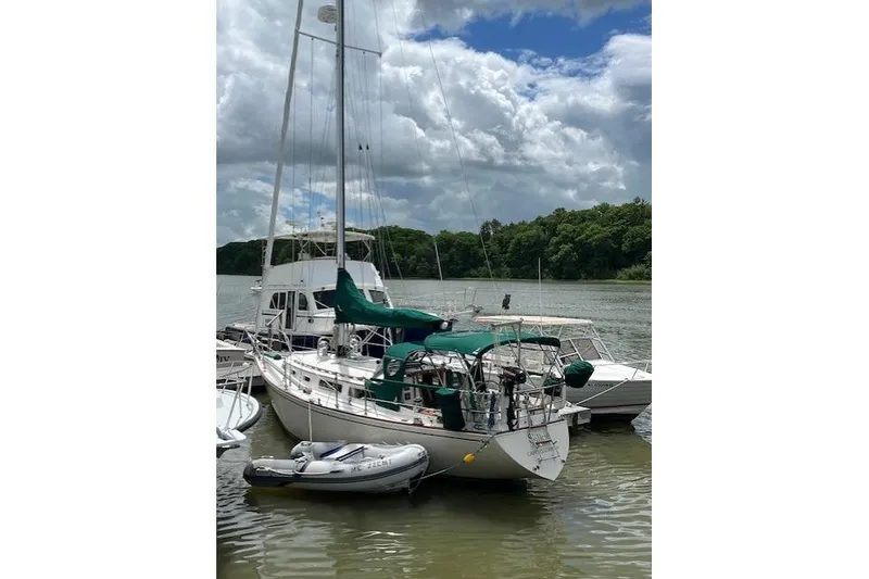 Slide: The Image of 1982 Sabre 34 sailboat docked on a calm river under cloudy skies. - 51