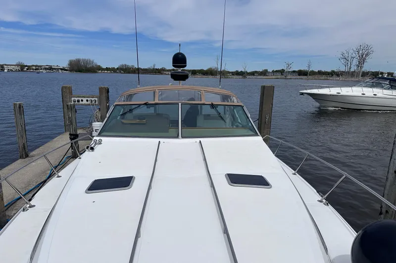 Slide: The Image of 1989 Sea Ray 390 Express Cruiser docked at a marina, calm water background. - 11