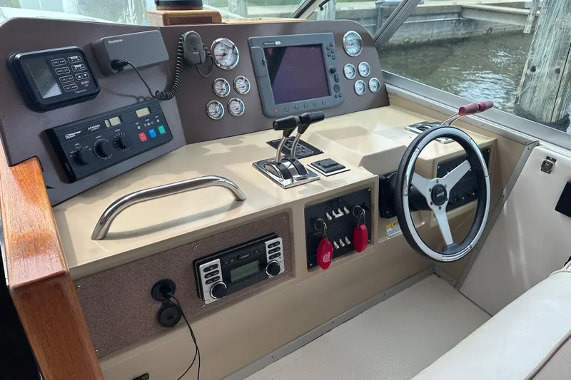 Slide: The Image of Cockpit of 1989 Sea Ray 390 Express Cruiser with steering wheel and navigation controls. - 16