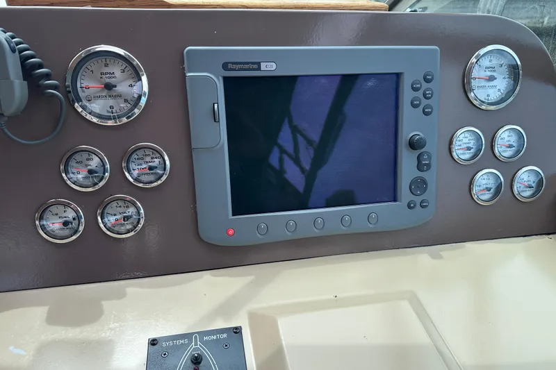 Slide: The Image of Control panel of a 1989 Sea Ray 390 Express Cruiser with gauges and navigation display. - 18