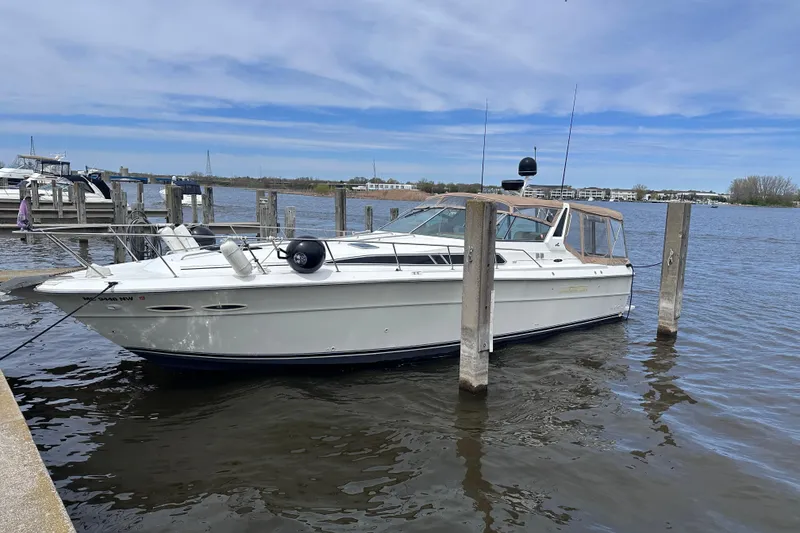Slide: The Image of 1989 Sea Ray 390 Express Cruiser docked at marina, calm waters, clear sky. - 2