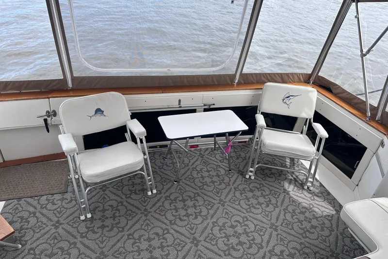 Slide: The Image of 1989 Sea Ray 390 Express Cruiser interior with two chairs and a small table. - 20
