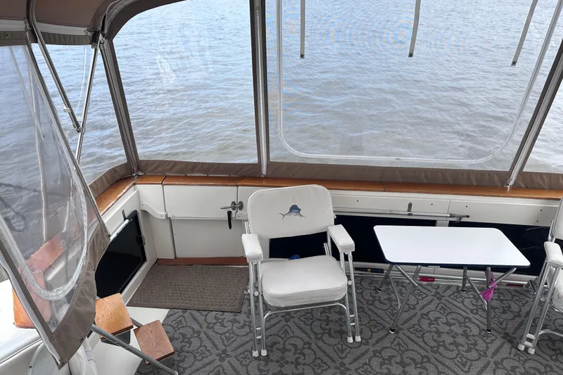 Slide: The Image of 1989 Sea Ray 390 Express Cruiser interior with chairs and table overlooking water. - 21