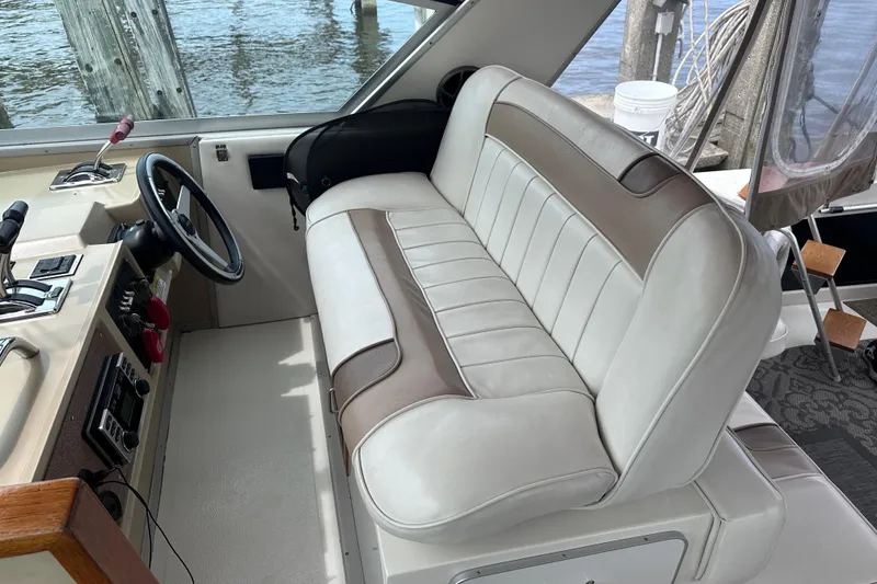 Slide: The Image of 1989 Sea Ray 390 Express Cruiser helm with beige leather seating and steering wheel. - 23