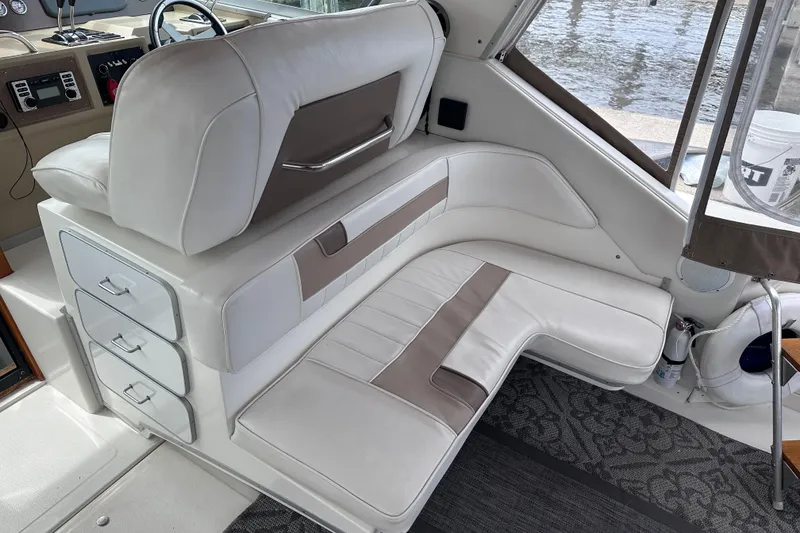 Slide: The Image of Interior of 1989 Sea Ray 390 Express Cruiser with white leather seating and storage drawers. - 25