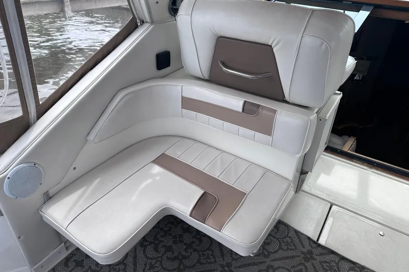 Slide: The Image of 1989 Sea Ray 390 Express Cruiser interior seating with white and brown upholstery. - 26