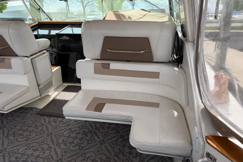 Slide: The Image of 1989 Sea Ray 390 Express Cruiser interior with white and brown seating, featuring a patterned carpet. - 27