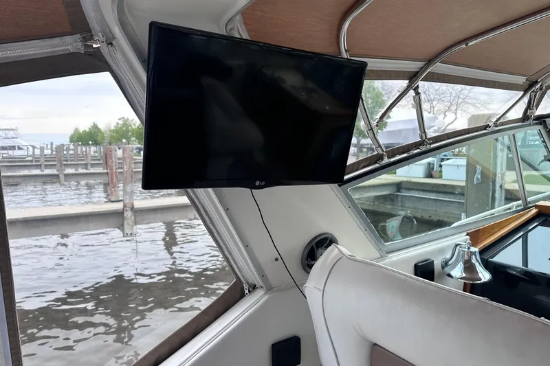 Slide: The Image of Interior of 1989 Sea Ray 390 Express Cruiser with mounted TV and marina view. - 29