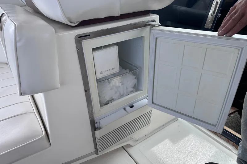 Slide: The Image of Open ice maker on 1989 Sea Ray 390 Express Cruiser, showing ice compartment and seating area. - 30
