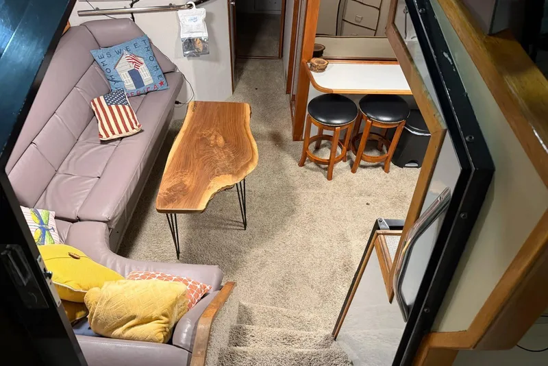 Slide: The Image of Interior of 1989 Sea Ray 390 Express Cruiser with cozy seating and wooden table. - 31