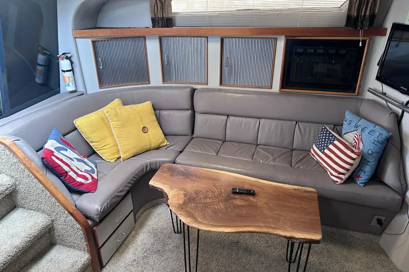 Slide: The Image of Cozy interior of 1989 Sea Ray 390 Express Cruiser with plush seating and decorative pillows. - 32