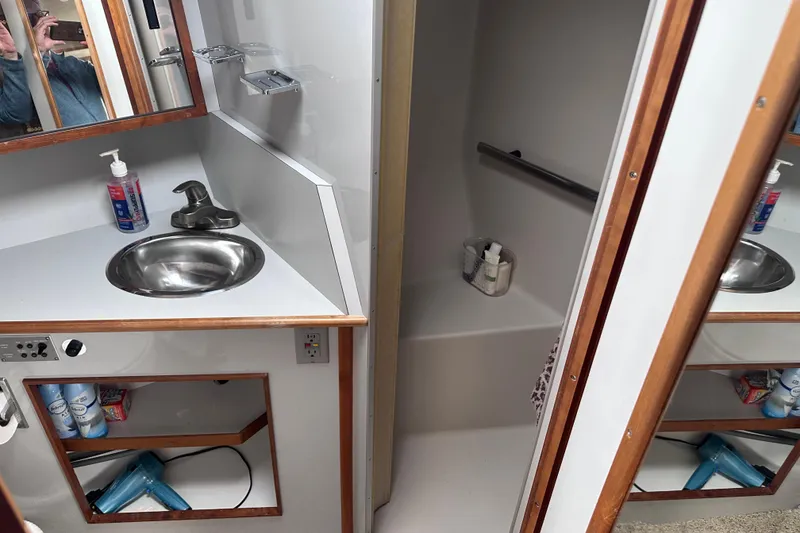 Slide: The Image of Bathroom interior of 1989 Sea Ray 390 Express Cruiser with sink and shower. - 34