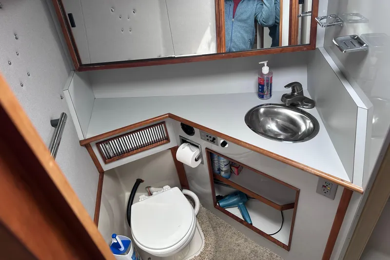Slide: The Image of 1989 Sea Ray 390 Express Cruiser bathroom with sink, mirror, and toilet. - 35